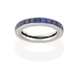 A Sapphire Eternity Ring, the calibré cut sapphires in a white channel setting, finger size I see