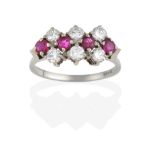 A Ruby and Diamond Cluster Ring, four round cut rubies spaced by three pairs of round brilliant
