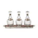 An Elizabeth II Silver-Mounted Decanter Stand With Three Cut-Glass Decanters and Wine-Labels, The