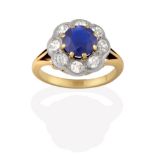 A Sapphire and Diamond Cluster Ring, the round cut sapphire in yellow claw settings, within a border