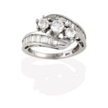 A Diamond Three Stone Twist Ring, the graduated round brilliant cut diamonds in white claw settings,