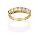 A Diamond Seven Stone Ring, the graduated round brilliant cut diamonds in yellow claw settings, to a