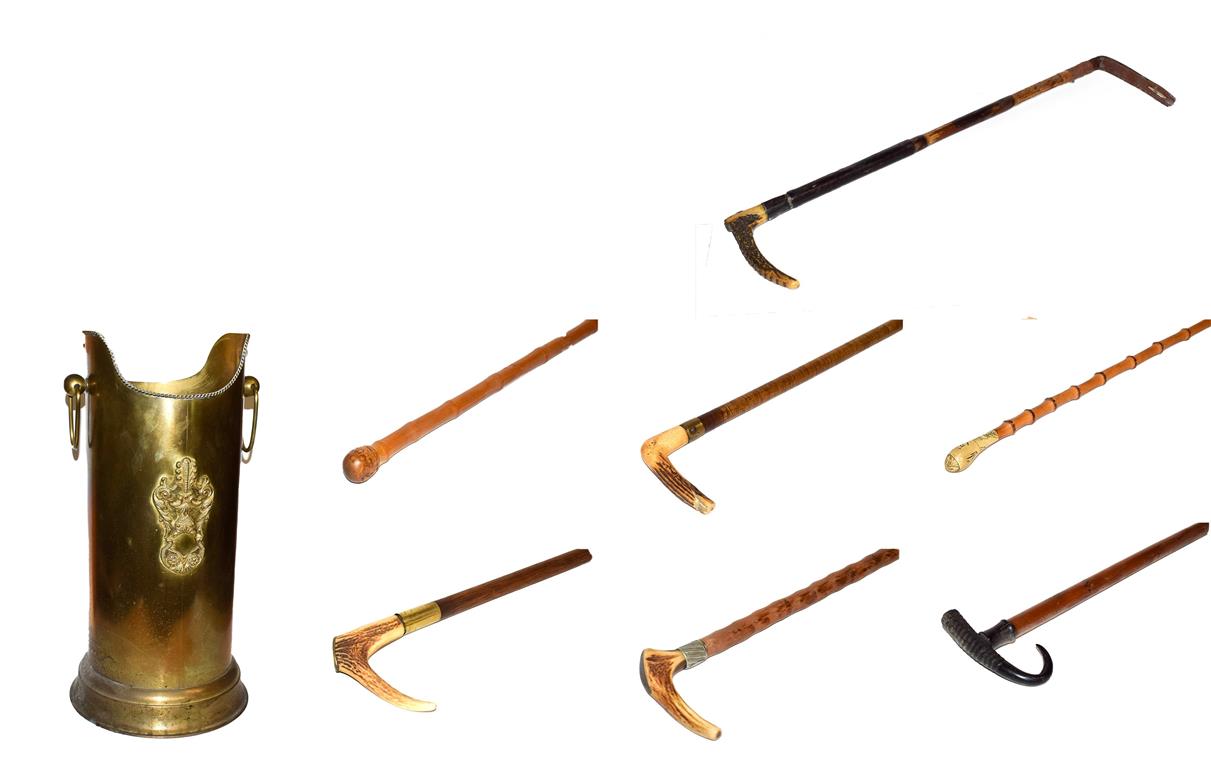 ~ A brass stick stand with loop handles containing six walking sticks and a riding crop, including