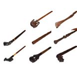 ~ A collection of carved walking sticks including African hardwood examples with figural and