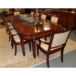 An impressive reproduction crossbanded mahogany gilt metal mounted extending dining table with two