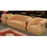 An early 20th century Chesterfield three-piece suite upholstered in buttoned fabric, comprising a