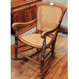 A 19th century elm cane childs rocking chair