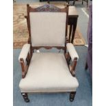 A Victorian carved mahogany upholstered fireside armchair