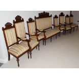 ~ A Continental walnut nine piece suite comprising; a settle, pair of armchairs, six single chairs