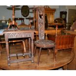 A carved oak spinning chair, a carved oak occasional table with twin brass stretchers and a