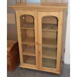 A glazed pine bookcase, 91cm by 45cm by 128cm high