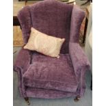 A purple upholstered wing armchair in the Georgian style