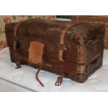 A 19th century brown leather trunk, hinged and enclosing a blue and white striped cotton lining to