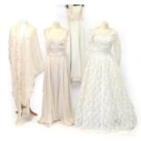 Three Early 20th Century Wedding Dresses, comprising a cream silk halter neck dress, woven with