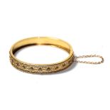 A 15 carat gold hinged bangle with rope twist decoration, to a plain polished hinged back,