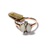 An opal and diamond ring, the two oval cabochon opals with round brilliant cut diamond accents, in