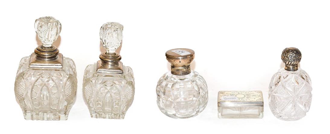 Four George V cut glass scent bottles with silver mounts, together with a Victorian cut glass and