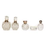 Four George V cut glass scent bottles with silver mounts, together with a Victorian cut glass and