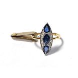 A sapphire and diamond ring, the navette shape formed of an oval sapphire and two pear cut sapphires