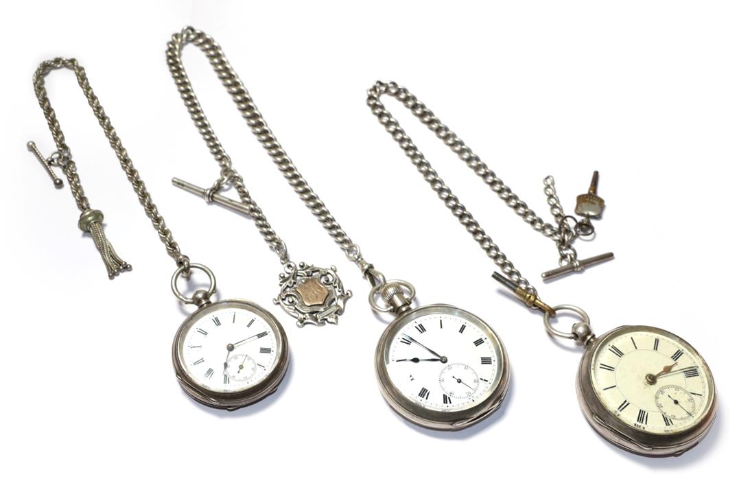 Three silver open faced pocket watches, with two attached silver curb link chains and attached