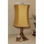 A gilt bronze based table lamp, raised on a scalloped circular plinth over scroll supports.