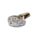 A diamond cluster ring, of openwork scroll design, set throughout with round brilliant cut