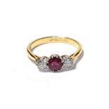 A ruby and diamond three stone ring, the round cut ruby flanked by round brilliant cut diamonds in