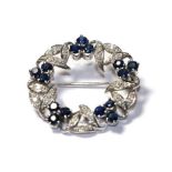 A sapphire and diamond brooch, realistically modelled as a wreath, clusters of three round cut