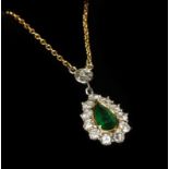 An 18 carat gold emerald and diamond cluster necklace, the pear cut emerald in a yellow rubbed