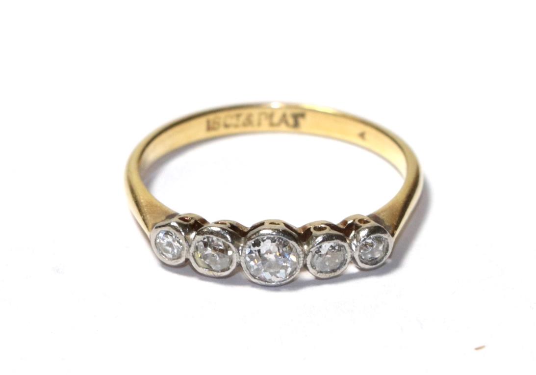 A diamond five stone ring, the old cut diamonds in white rubbed over settings, to a yellow tapered