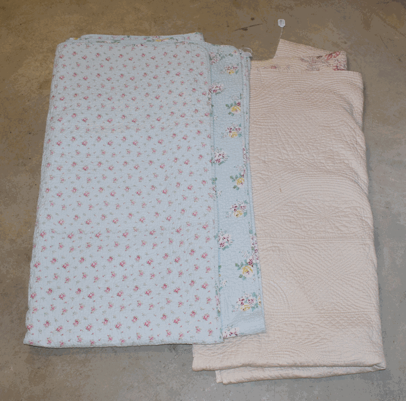 A quilt with pink printed flower heads to one side, cream to the reverse and a pale blue double