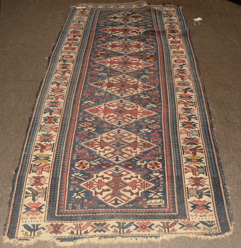 Kuba rug, the deep indigo field with a column of medallions enclosed by ivory borders 225cm by 108cm