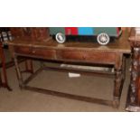 A late 17th/early 18th century walnut two-drawer table, raised on turned supports with bar