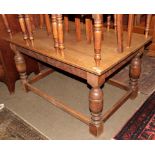 A carved oak refectory table with turned bulbous legs joined stretchers, 137cm by 90cm by 75cm