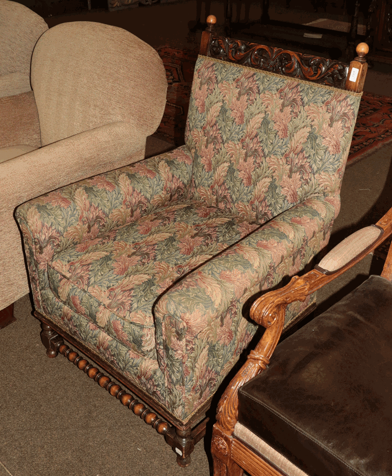 An early 20th century carved oak upholstered armchair