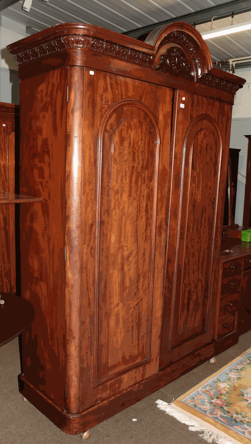 A Victorian mahogany double wardrobe with carved arch top pediment and fitted interior, 140cm by