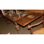 A Jacobean style carved oak refectory dining table with drawer leaves and pineapple supports,