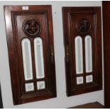 A pair of 19th century Flemish carved walnut bevelled glass panels decorated with masks, formerly