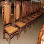 A set of ten carved walnut dining chairs in the Baronial style with cane work seats and back rests