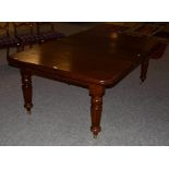 A Victorian mahogany wind out dining table with two additional leaves