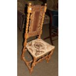 A 17th century style hall chair with carved top rail, cane back and seat