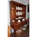 A 19th century oak dresser and rack, the upper section with scroll carved apron, the base fitted