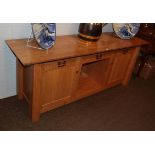 A Treske Furniture solid oak sideboard, the rectangular top above a central frieze door over a