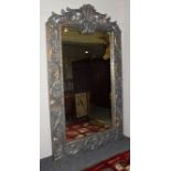 A large imposing parcel gilt mirror with scrolling open work pediment and further scroll work to the