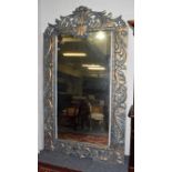 A large imposing parcel gilt mirror with scrolling open work pediment and further scroll work to the