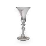 A baluster wine glass, circa 1740, the bell shaped bowl on an annular knop and baluster stem with