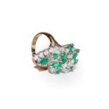 An emerald and diamond ring, the abstract spray set throughout with round brilliant cut diamonds and