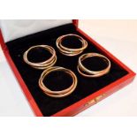 A cased set of four silver plate and gilt plate napkin rings, retailed by Cartier, 20th Century,