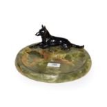 A 1920s bronze model of a recumbent German Shepherd mounted on a circular onyx base, 24cm diameter