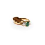 An 18 carat gold emerald and diamond three stone ring, the step cut emerald flanked by round